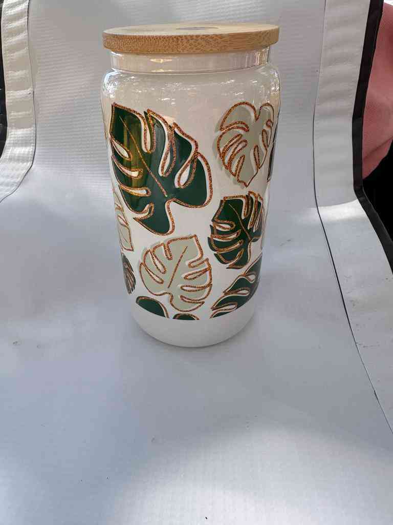 Premium Glass Can with green and gold monstera leaf design, eco-friendly and ideal for storing refreshing beverages in style.