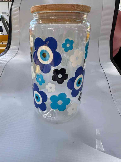 Eco-friendly Premium Glass Can decorated with blue and white floral evil eye pattern, combining charm and beverage freshness.